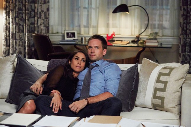 Meghan Markle as Rachel Zane cuddling up to Patrick J. Adams as Michael Ross on the sofa in Suits