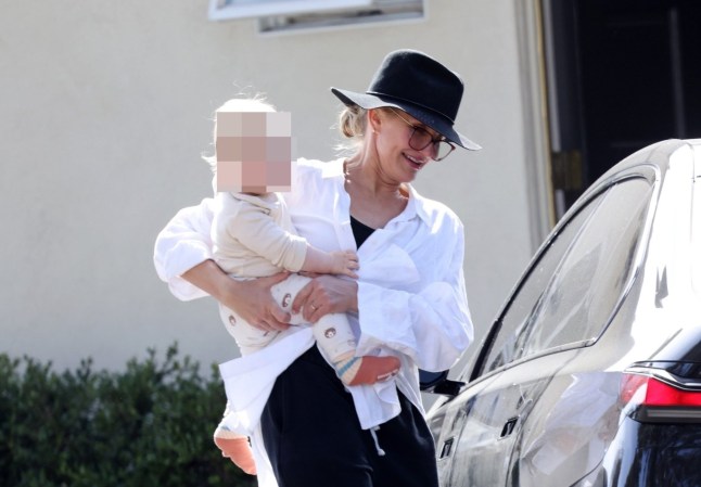Cameron Diaz smiling as she leaves a restaurant in Santa Barbara with her son Cardinal in her arms. His face is pixelated.