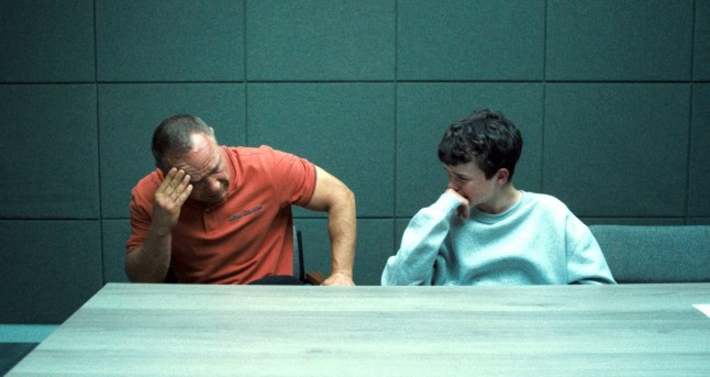 Stephen Graham as Eddie Miller and Owen Cooper as Jamie Miller, in Adolescence, both looking stressed in a police interview room.