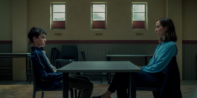 Owen Cooper as Jamie Miller sat opposite Erin Doherty as Briony Ariston in Adolescence