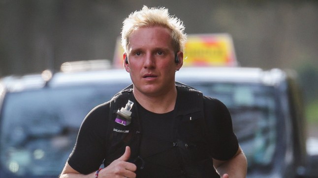 Jamie Laing wearing a black t-shirt and backpack running an ultramarathon for Comic Relief