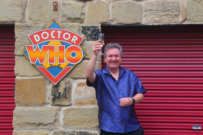 David Howe stood in front of a sign with Doctor Who on it.