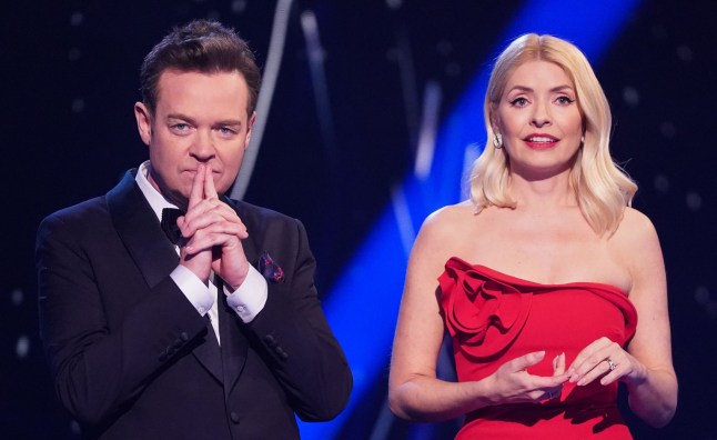 Stephen Mulhern and Holly Willoughby presenting Dancing on Ice. He wears a suit and she wears a red dress.