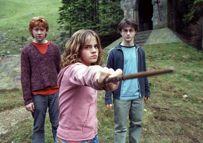 Rupert Grint as Ron Weasley, Emma Watson as Hermione Granger flexing a wand and Daniel Radcliffe as Harry Potter in Harry Potter