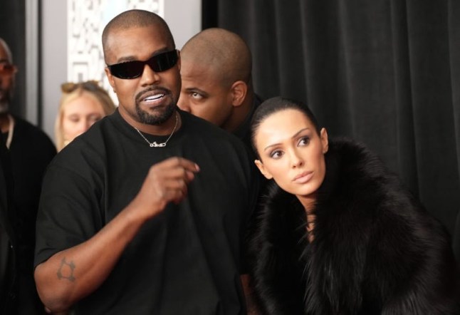 Kanye West and Bianca Censori on the red carpet. She wears fur coat and he wears black t-shirt.