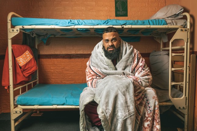 Guz Khan as Mobeen in a blanket sat on bunk beds