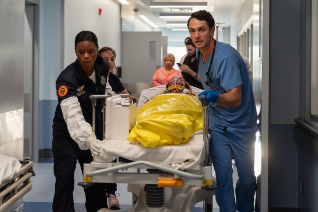 Colin Woodell as Xander Phillips in Pulse leading doctors pushing a patient down a hallway.