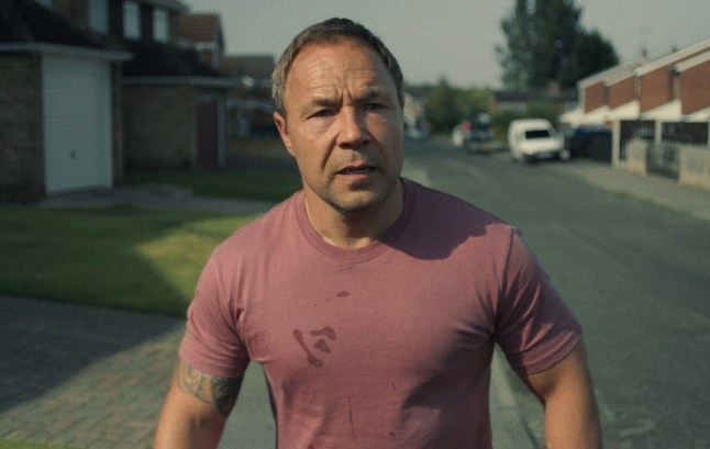 Stephen Graham as Eddie Miller walking down a surburban street in Adolescence.