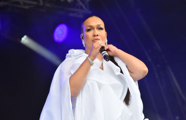 Rebecca Ferguson wearing white and performing at a festival
