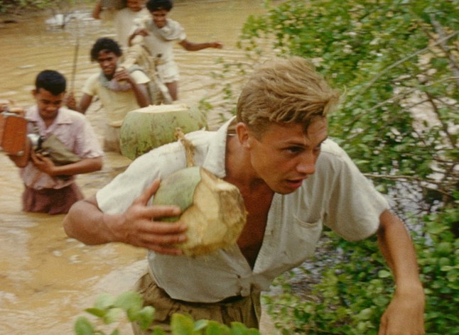 David Attenborough (carrying coconuts) in 1950s documentary Zoo Quest