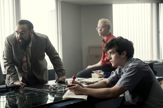 Asim Chaudhry, Will Poulter, Fionn Whitehead in Black Mirror Bandersnatch gathered around a table
